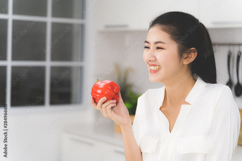 Portrait of Asian beautiful woman is smiling and showing bell pepper in hands. Healthy food concept. Portrait of Asian beautiful woman is smiling and showing bell pepper in hands. Healthy food concept.