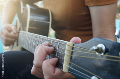 Woman playing acoustic guitar. guitar closeup