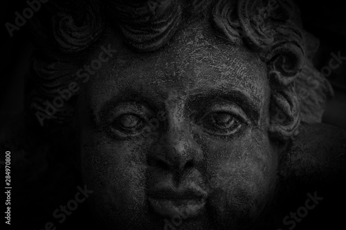 The statue's eye in the black background. © Tanakrit
