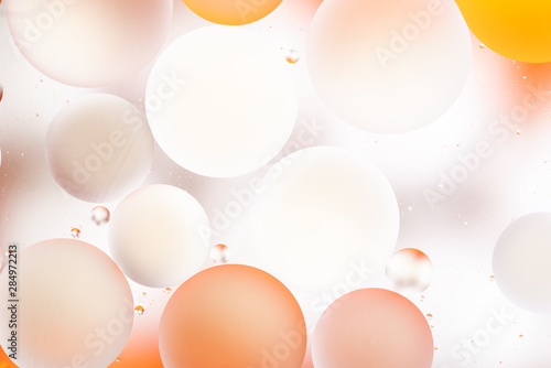 bright oily drops in water with colorful background, close-up 