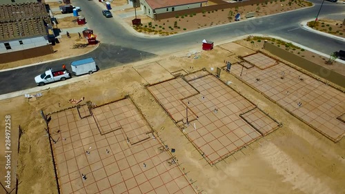 Aerial shot of new homes foundation being built then panning up to the rest of the construction project