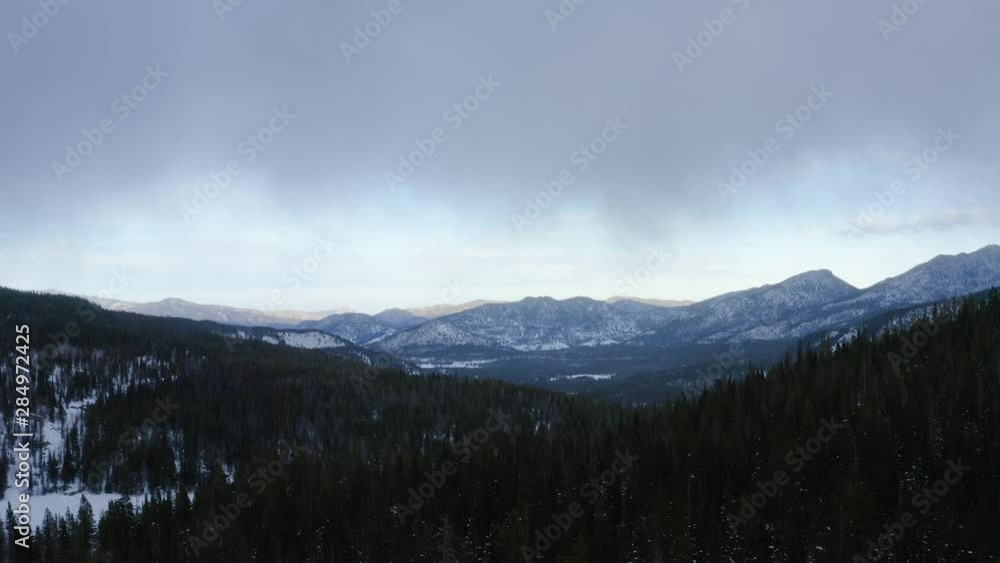 Aerial forward shot of snowy mountains overlooking the horizon Aerial forward shot of snowy mountains overlooking the horizon