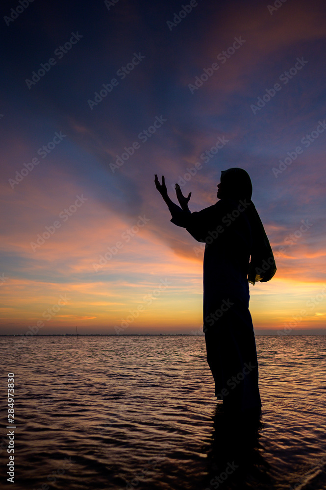 Islamic Woman Praying by the ocean for prayer, saying graces, religion use