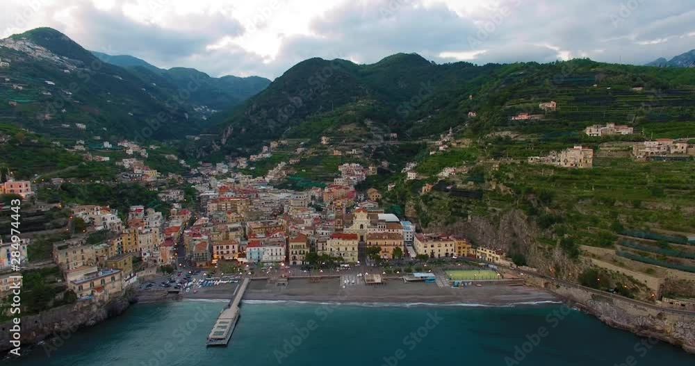 AERIAL LIFT historic township of Ravello, Italy. Calm ocean waters lap the beach AERIAL LIFT historic township of Ravello, Italy. Calm ocean waters lap the beach
