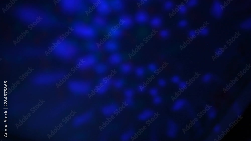 Blue bokeh revolving unfocused. Festive illuminations on a dark background. Blue bokeh revolving unfocused. Festive illuminations on a dark background.