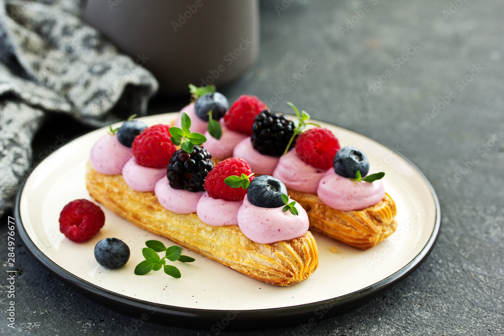 Homemade eclair with berry cream and fruits. . Pastry. Homemade eclair with berry cream and fruits. . Pastry.