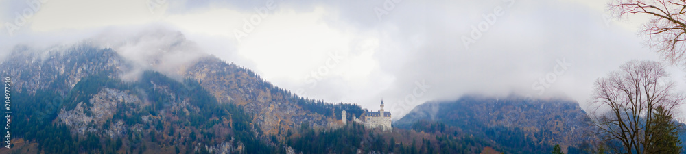 Beautiful view of world-famous Neuschwanstein Castle on the mountain in rainy day, southwest Bavaria, Germany  