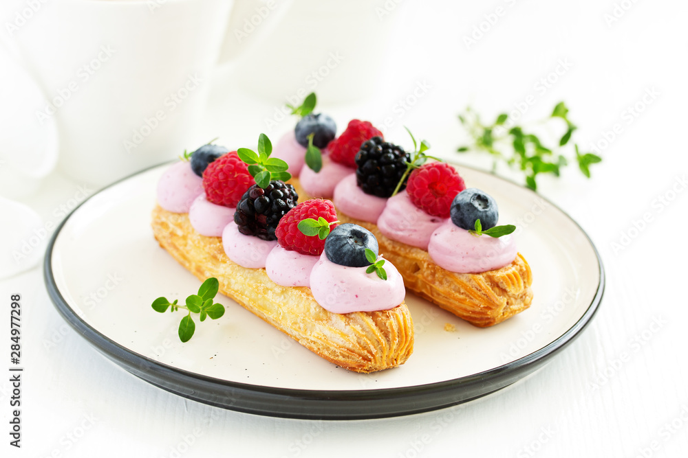 Homemade eclair with berry cream and fruits. . Pastry. Homemade eclair with berry cream and fruits. . Pastry.