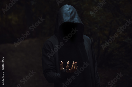 Man in a hood with light on his hand
