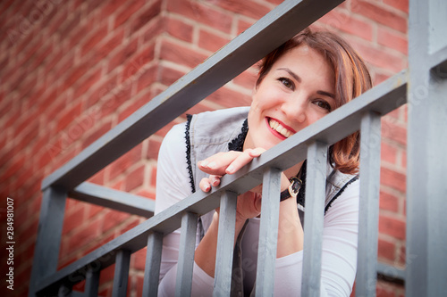 Brunette funny pretty girl on roof in Central part of old city. Walk in downtown. Portrait of a girl on the street