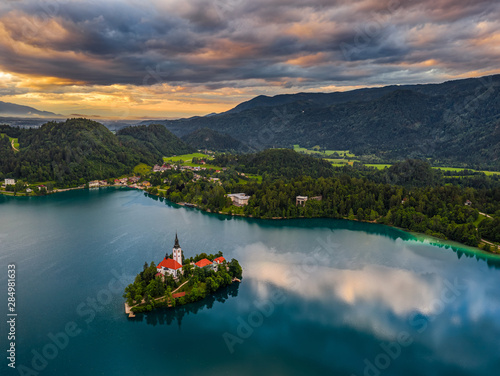 Bled, Slovenia - Beautiful aerial view of Lake Bled (Blejsko Jezero) with the Pilgrimage Church of the Assumption of Maria on a small island and dramatic reflecting clouds and sky at summer time