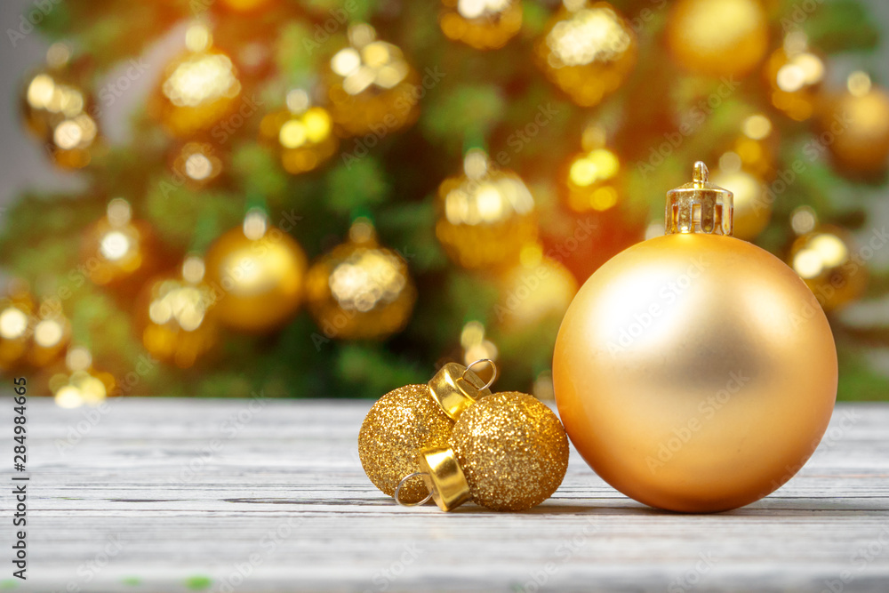 Christmas baubles on wooden table against decorated christmas tree blurred background Christmas baubles on wooden table against decorated christmas tree blurred background