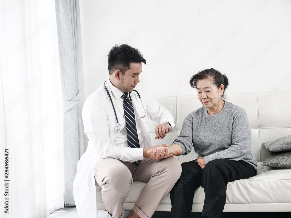 Asian doctor checking up his patient old woman in office. Asian doctor checking up his patient old woman in office.
