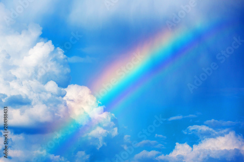 Rainbow on a blue sky with white clouds