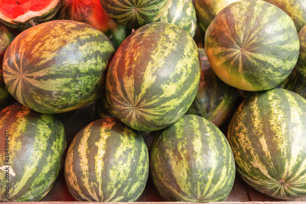 Ripe watermelons are on the market counter.