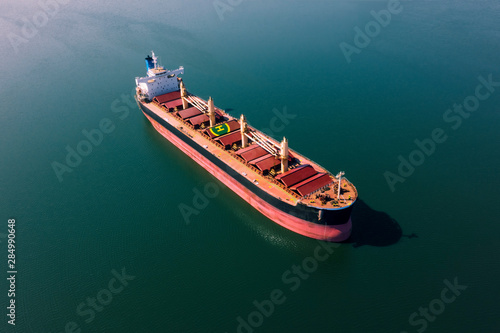 Shipping cargo to harbor by ship. Water transport International. Aerial view