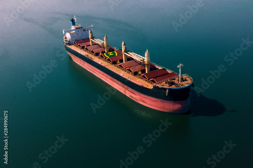 Shipping cargo to harbor by ship. Water transport International. Aerial view