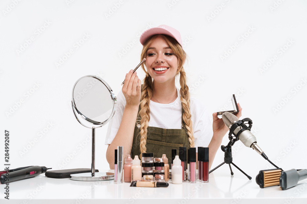 Smiling young blonde girl blogger making a beauty video