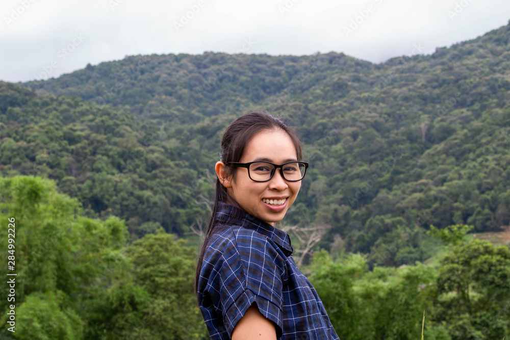 Portrait of young happy woman stand and smile on mountain background.