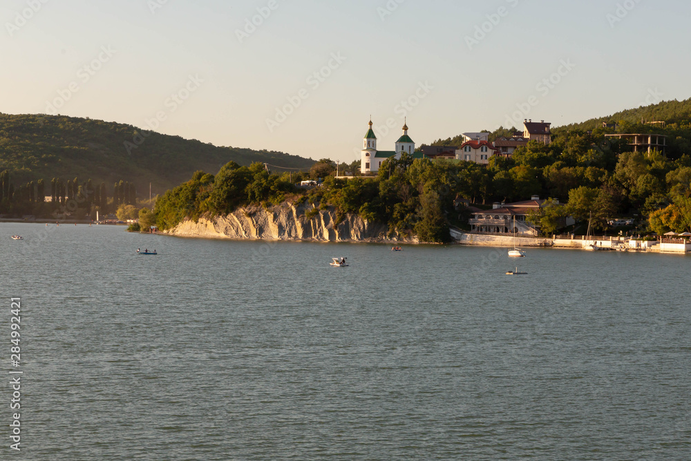 Beautiful lake landscape with forest, promenade and Church on the hill.