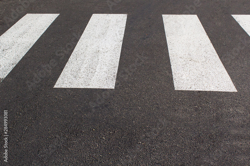 white zebra pedestrian way city lines on the grey asphalt road