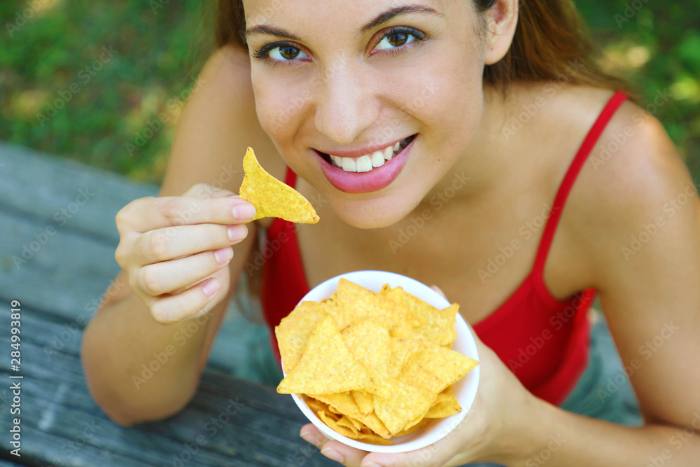 Close up view from above of beautiful young woman eating tortilla chips outdoor. Close up view from above of beautiful young woman eating tortilla chips outdoor.