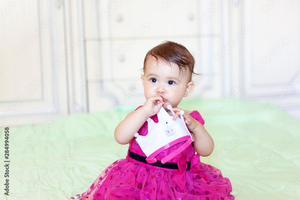 First birthday. Little cheerful baby girl with crown celebrating her first birthday party First birthday. Little cheerful baby girl with crown celebrating her first birthday party