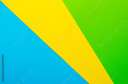 Free Download Colored paper: green, blue, yellow. Abstract colorful background, top view. Copy space, banner template. Flat lay - GFXLoad