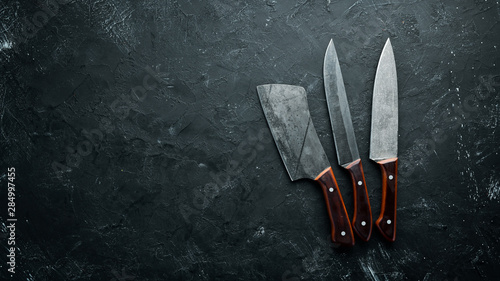 Kitchen old knife on a black stone table. Top view. Free space for your text.