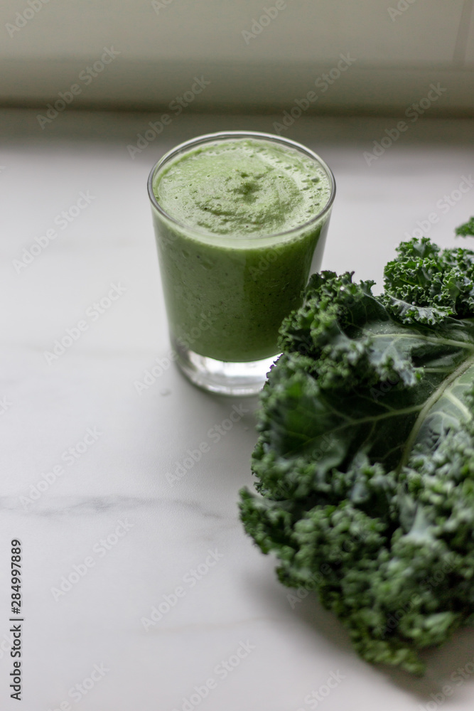 Green smoothies with kale, banana and apple on marble background with copy space Green smoothies with kale, banana and apple on marble background with copy space