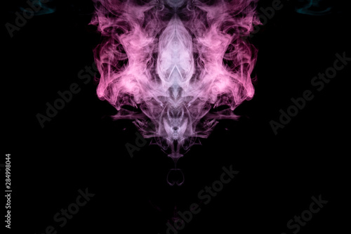 Smoke of different blue, red and pink colors in form of horror in the shape of the head, face and eye with wings on a black isolated background. Soul and ghost in mystical symbol. Print for clothes. © Aleksandr Kondratov