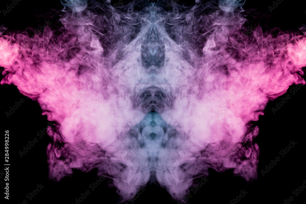 Fototapeta premium Smoke of different blue, red and pink colors in form of horror in the shape of the head, face and eye with wings on a black isolated background. Soul and ghost in mystical symbol. Print for clothes.