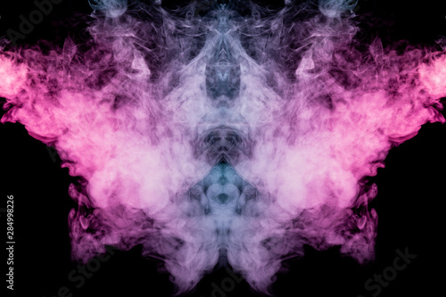 Smoke of different blue, red and pink colors in form of horror in the shape of the head, face and eye with wings on a black isolated background. Soul and ghost in mystical symbol. Print for clothes.