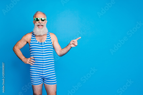 Portrait of his he nice attractive content funky excited positive cheerful cheery gray-haired man showing advice ad advert solution isolated over bright vivid shine turquoise blue background