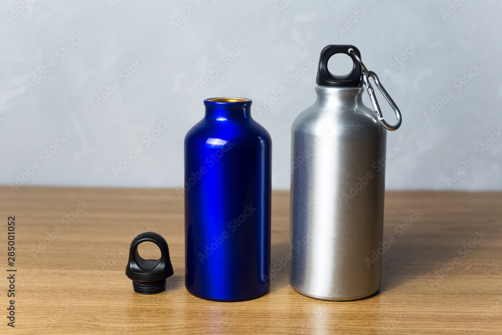 Two miscellaneous thermo bottle on the wooden table Two miscellaneous thermo bottle on the wooden table