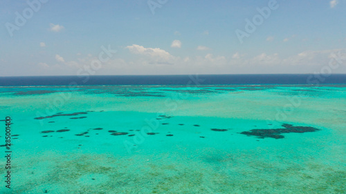Fototapeta Naklejka Na Ścianę i Meble -  Tropical coral atoll with turquoise water against the sky with clouds top view. Summer and travel vacation concept. Balabac, Palawan, Philippines