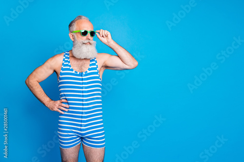 Portrait of his he nice attractive content cool sportive trendy stylish gray-haired man spending summertime isolated over bright vivid shine turquoise blue green background