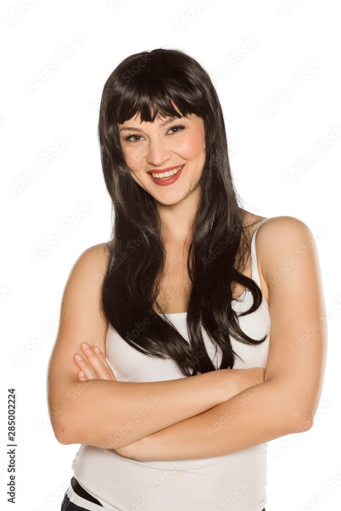 Young beautiful woman posing with long black wig on white background Young beautiful woman posing with long black wig on white background