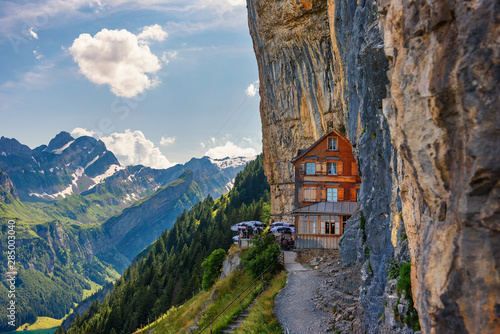 Swiss Alps and a restaurant under a cliff on mountain Ebenalp in Switzerland photo