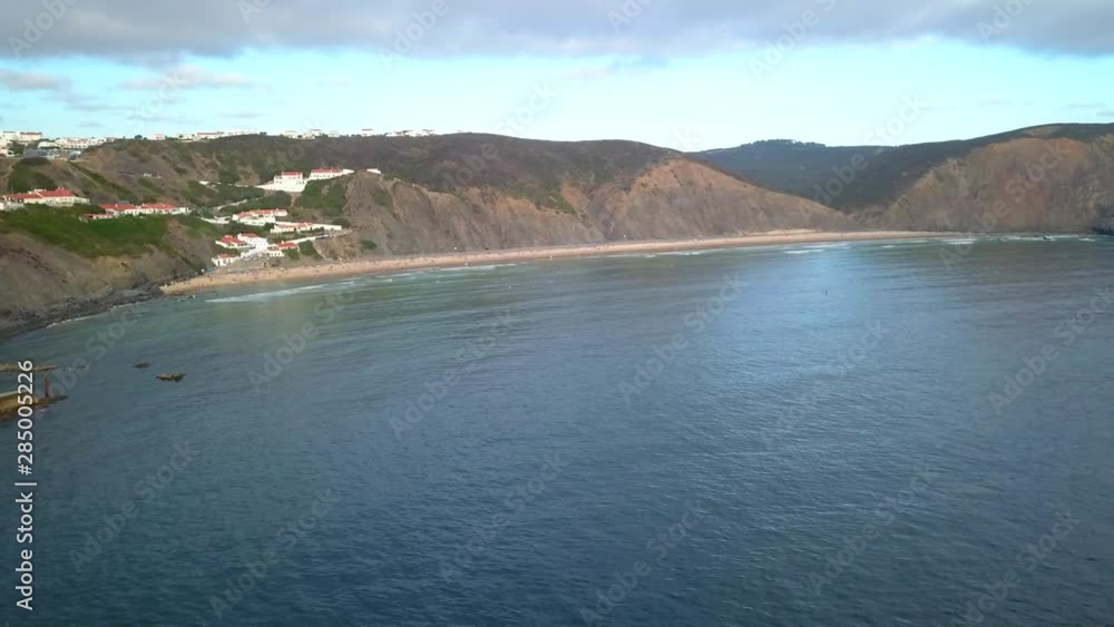 Aerial, drone shot, of the Arrifana Beach, overlooking people and surfers, on the Atlantic shore, on a sunny day, in Vicentina coast national park, in Portugal Aerial, drone shot, of the Arrifana Beach, overlooking people and surfers, on the Atlantic shore, on a sunny day, in Vicentina coast national park, in Portugal