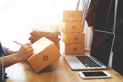 Online selling e-commerce shipping idea concept, Women freelance start up small business owner packing cardboard box at workplace