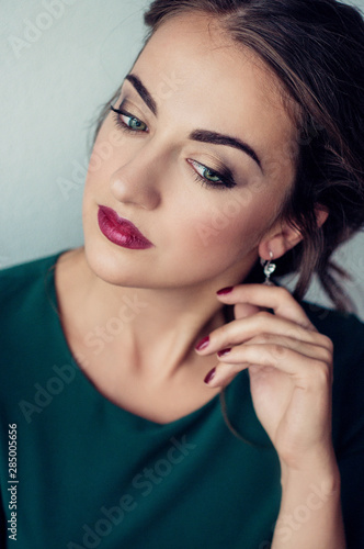 Face of a beautiful young girl with a clean fresh face close up.Brunette women with green eyses red lips.