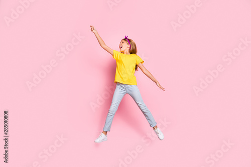 Full length body size view of her she nice attractive cheerful cheery overjoyed carefree pre-teen girl wearing yellow t-shirt having fun holding in hand invisible parasol isolated over pink background © deagreez