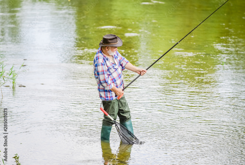 Retired fisherman. Senior man catching fish. Mature man fishing. Male leisure. Fisherman with fishing rod. Activity and hobby. Fishing freshwater lake pond river. Happiness is rod in your hand Retired fisherman. Senior man catching fish. Mature man fishing. Male leisure. Fisherman with fishing rod. Activity and hobby. Fishing freshwater lake pond river. Happiness is rod in your hand