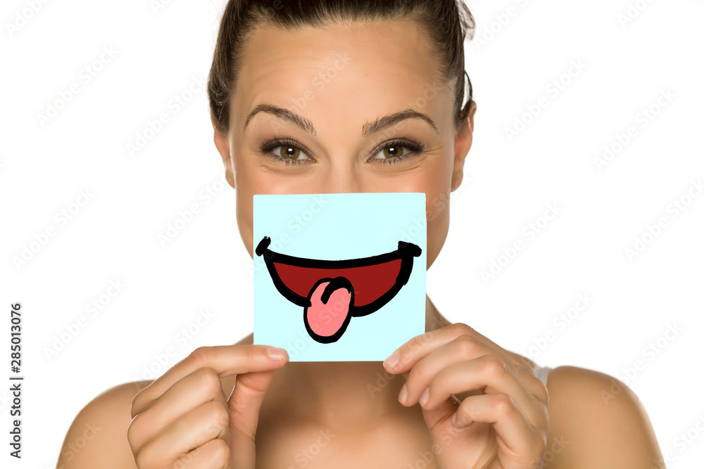 a young happy woman with a drawn smile on paper on a white background a young happy woman with a drawn smile on paper on a white background