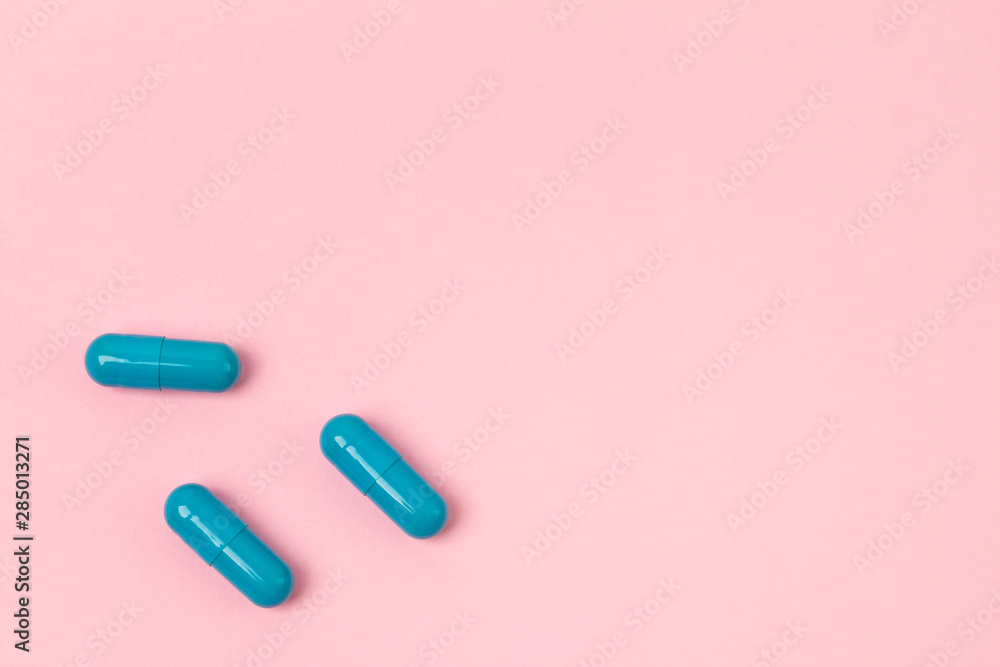 Blue pills at pink background.Flat lay. Empty place for text. Blue pills at pink background.Flat lay. Empty place for text.