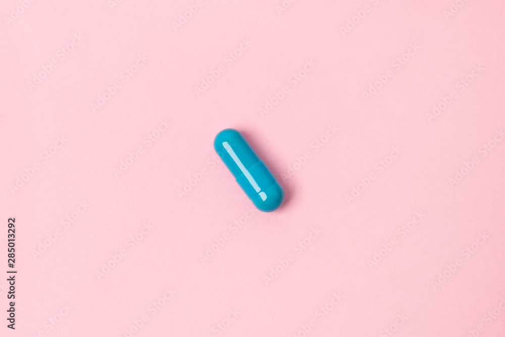 Blue pill at pink background. Flat lay top view. Blue pill at pink background. Flat lay top view.