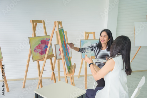 two young asian woman artist figure is sitting the drawing. using ideas to think and elaborate on the beautiful fish. and create the best artwork.