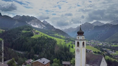 Wallpaper Mural Aerial Flight over small alpine village in the Dolomites. Flying over the church bell tower. European Alps. Tyrol. San Vigilio. 4K Torontodigital.ca