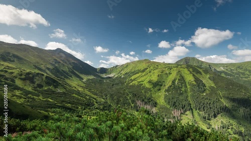 Summer Day at Trzydniowianski Peak, Panoramic View Over Chocholowska Valley in Poland Tatra Mountains Range. Moving Clouds on Blue Sky. Green Meadows and Forest in Valley. photo